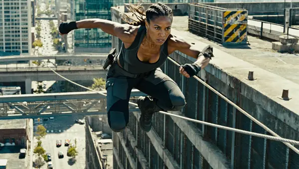 Z Image cinematic digital art output — powerful woman of mixed Native American and African heritage mid-stunt on an urban rooftop with city skyline backdrop and dramatic natural lighting